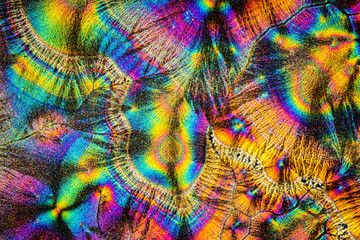 Extreme macro photograph of Vitamin C crystals forming abstract modern art patterns under polarized light