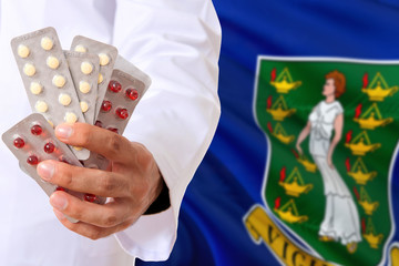 British Virgin Islands pharmacy and medicine concept. Doctor holding pills tablet on national flag background. Health theme with copy space for text.