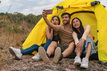 diverse people of caucasian and asian friends having fun together traveling and camping in natural resort