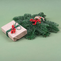 Beautiful Christmas present in craft paper and pine branch.