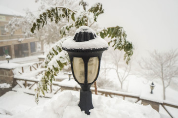 outdoor vintage light lamp covered with white snowfall in winter