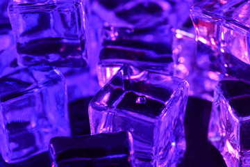 Ice cube. Close-up of ice cubes with  pink and purple backlight  thawn. Macro horizontal photography