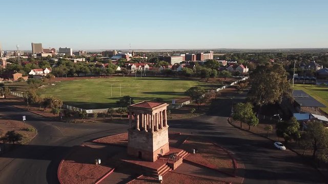 4K high quality sunny sunrise aerial footage of Honoured Dead Memorial classical architecture site at Sacred Circle road roundabout in Kimberley, capital of Northern Cape province, South Africa