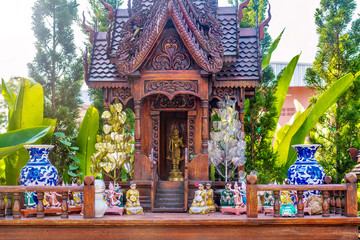 A Thai spirit house, a small replica of a traditional structure, where the deity or spiritual...