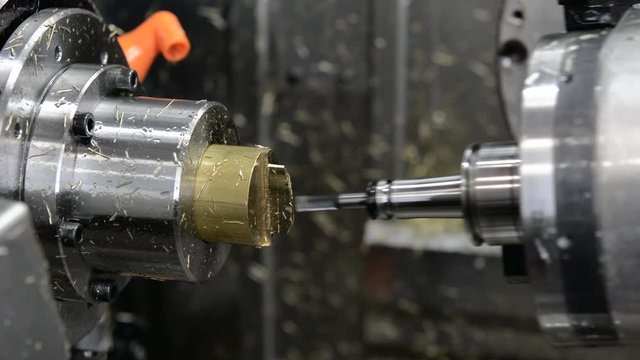 Five axis precision CNC machine tool milling brass on different angles.