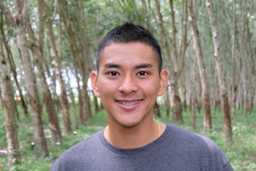 Selective focus young handsome asian man smiling with braces and looking at camera,Portrait of a smiling athletic young Asian man  an early morning,blurred and soft background. 