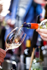 White wine is poured into a glass. Festive party