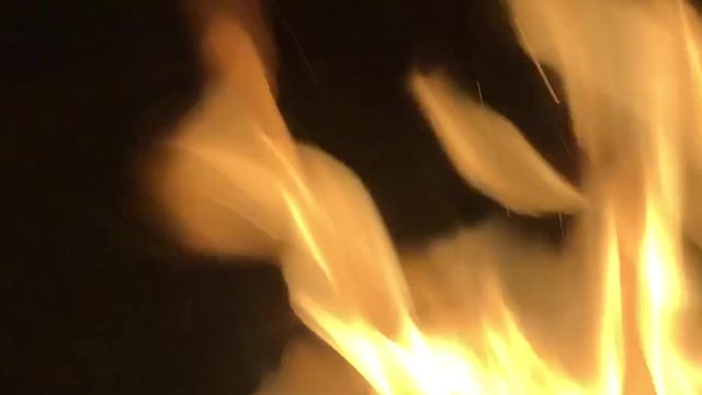 A steady slow motion shot of fire rolling into frame, flickering and flashing from the heat.