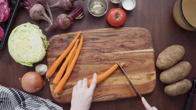 Step by step. Flat lay. Slicing orange carrots into the small cubes for beet soup, borscht.