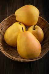 Naklejka na ściany i meble Ripe yellow pears on a wooden table