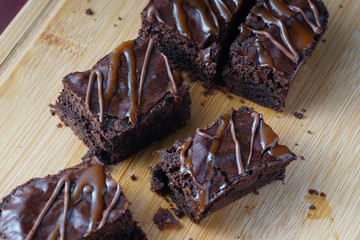Close up of moist dark chocolate brownies over wooden table.