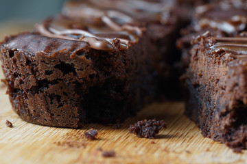 Close up of moist dark chocolate brownies over wooden table.