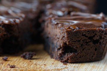 Close up of moist dark chocolate brownies over wooden table.
