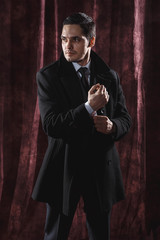 Fototapeta na wymiar Handsome man in a business suit on a dark background