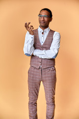 Vertical Portrait Young man with short-haired African American in a business suit on a pink background. Standing and talking right in front of the camera.