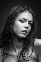 Expressive black white portrait of a young attractive girl with wet dark hair