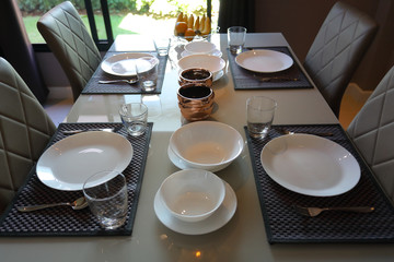 dish ware sets arrange on breakfast table in the morning inside eating room of modern home interior