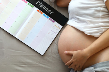 mother pregnant maternity hand hug tummy with love a baby, mom write planner schedule note happy memories