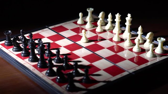 Slow rotating shot of chessboard with white first move e4 with dramatic lighting - 4K