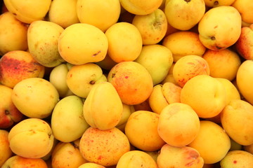 Lots of delicious looking very fresh peaches on sale at an outside market on a sunny Saturday.