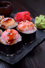 Sushi rolls assortment served on slate plate on black table