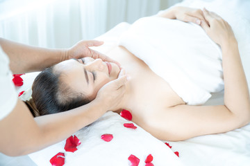 Obraz na płótnie Canvas Beautiful woman in spa. A beautiful Asian woman is doing facial massage in a spa shop.