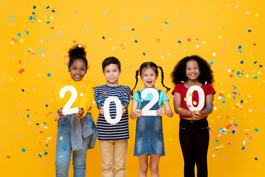 Cute smiling mixed race children showing numbers 2020 celebrating new year