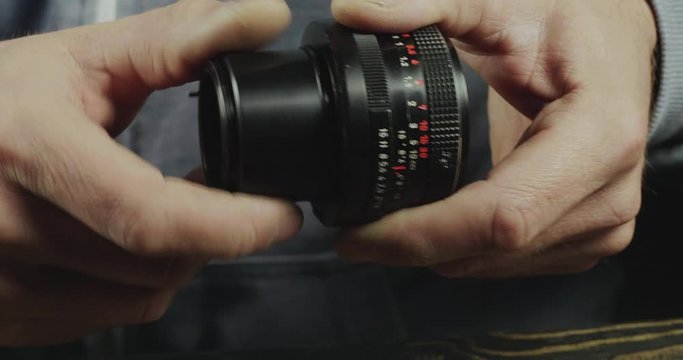 Close-Up Of A Male Hand Attaches A Macro Ring To The Lens. Photographer Mounts Macro Ring To A Manual Lens. Cinema 4K Video