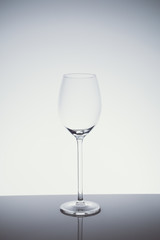 Wineglass on the light background.. Fine cristal glassware concept. Vertical, cold tone in light cold toning