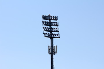 Back view of tall stadium metal column filled with reflectors in various sizes and cell phone...