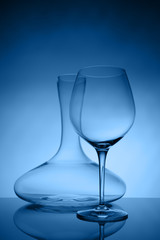 Glassware selection with wine glass and decanter on classic blue background. Fine cristal glassware concept. Vertical, classic blue tone