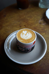 A ceramic mug of hot Latte on wooden table
