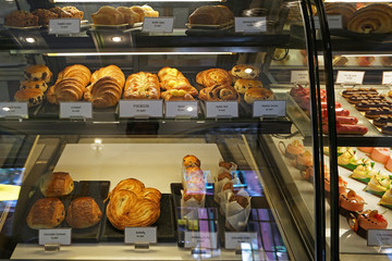 Assorted colorful eclair and French pastry bakery displayed in glass showcase box