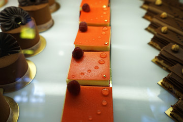 Close up French berry pastry cake with Hazelnut chocolate cacao cake displayed in glass showcase box