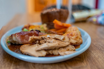 Selective focus of a traditional roast turkey dinner on a wooden table