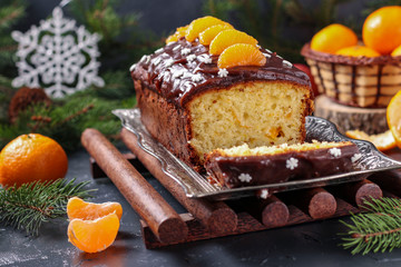 Cupcake with tangerines, covered with chocolate glaze is located on the New Year's background, Festive still life