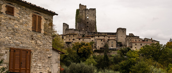 A view of the ruins of the medieval castle Rocca di Pierle in Tuscany, Italy with cloud shrouding the surrounding hills, nobody in the image