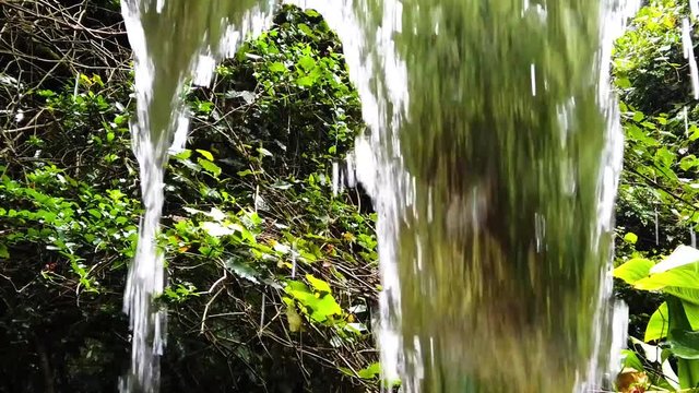 Behind a small waterfall in super slow motion.