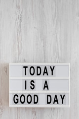 'Today is a good day' words on a lightbox on a white wooden background, top view. Overhead, from above, flat lay. Copy space.