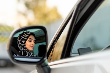 muslim young woman is driving car carelessly