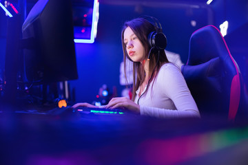 Streamer beautiful girl professional gamer smile playing online games computer with headphones,...