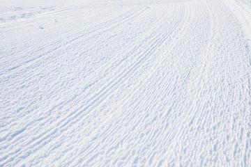 rolled ski slope, rilled snowy background