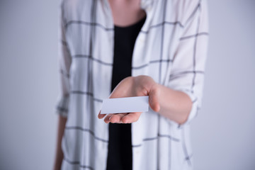 Young woman hand showing blank white bussines card.