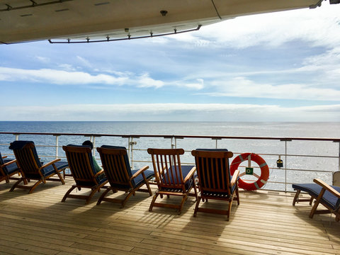 Fototapeta Wooden Deck chairs on Cunard luxury and legendary ocean liner Queen Mary 2 cruise ship QM2 on passage during Transatlantic Crossing from Southampton to New York