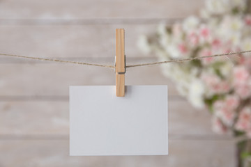 White notice card on the flowers and wooden background.