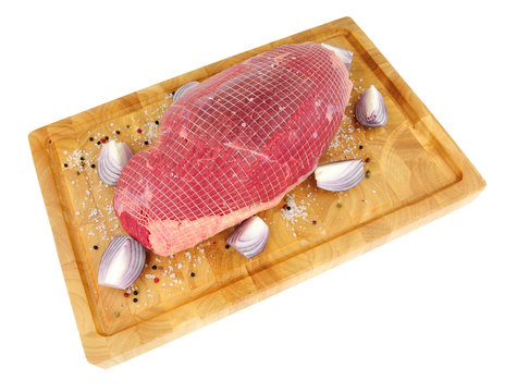 Raw beef roasting joint on a wooden chopping board isolated on a white background