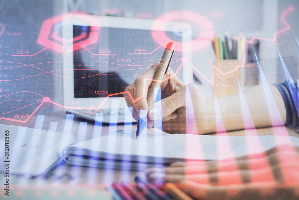 Wall mural Financial forex charts displayed on woman's hand taking notes background. Concept of research. Double exposure