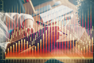 Financial forex charts displayed on woman's hand taking notes background. Concept of research. Double exposure