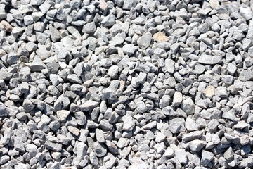 White and grey various sizes gravel at local construction site texture wallpaper background