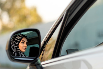 Fototapeta na wymiar young beautiful muslim woman driving her new car